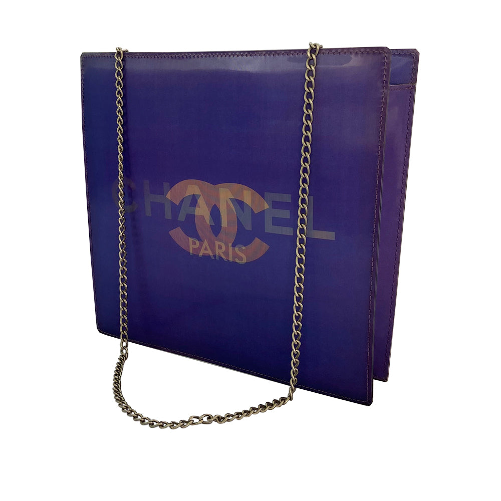 Chanel shoulder bag by Karl Lagerfeld for Chanel 2000. Rectangular vinyl bag with silver-tone double chain shoulder strap and lenticular/holograph design that flip flops between gold-tone interlocking CC logo and CHANEL Paris. Open top, vinyl interior, one zippered pocket. Made in France