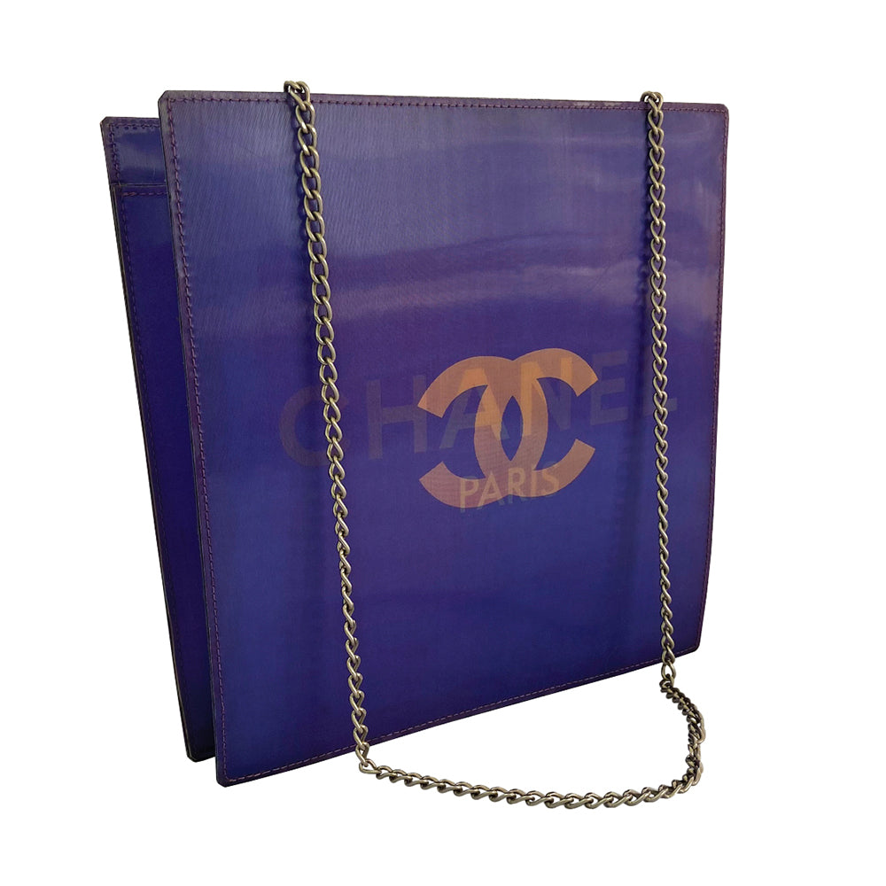Chanel shoulder bag by Karl Lagerfeld for Chanel 2000. Rectangular vinyl bag with silver-tone double chain shoulder strap and lenticular/holograph design that flip flops between gold-tone interlocking CC logo and CHANEL Paris. Open top, vinyl interior, one zippered pocket. Made in France