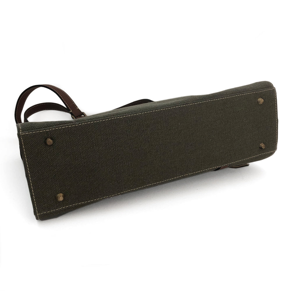 Christian Dior Canvas Saddle Tote by John Galliano. Olive canvas with brown leather handles and sides with front hanging brass logo D, accent stitching throughout. CD stamped brass-tone studs and links. Magnetic button closure. Brown Dior logo satin lining, suede and leather detail and side panels, single zip interior pocket. Brass-tone metal feet.