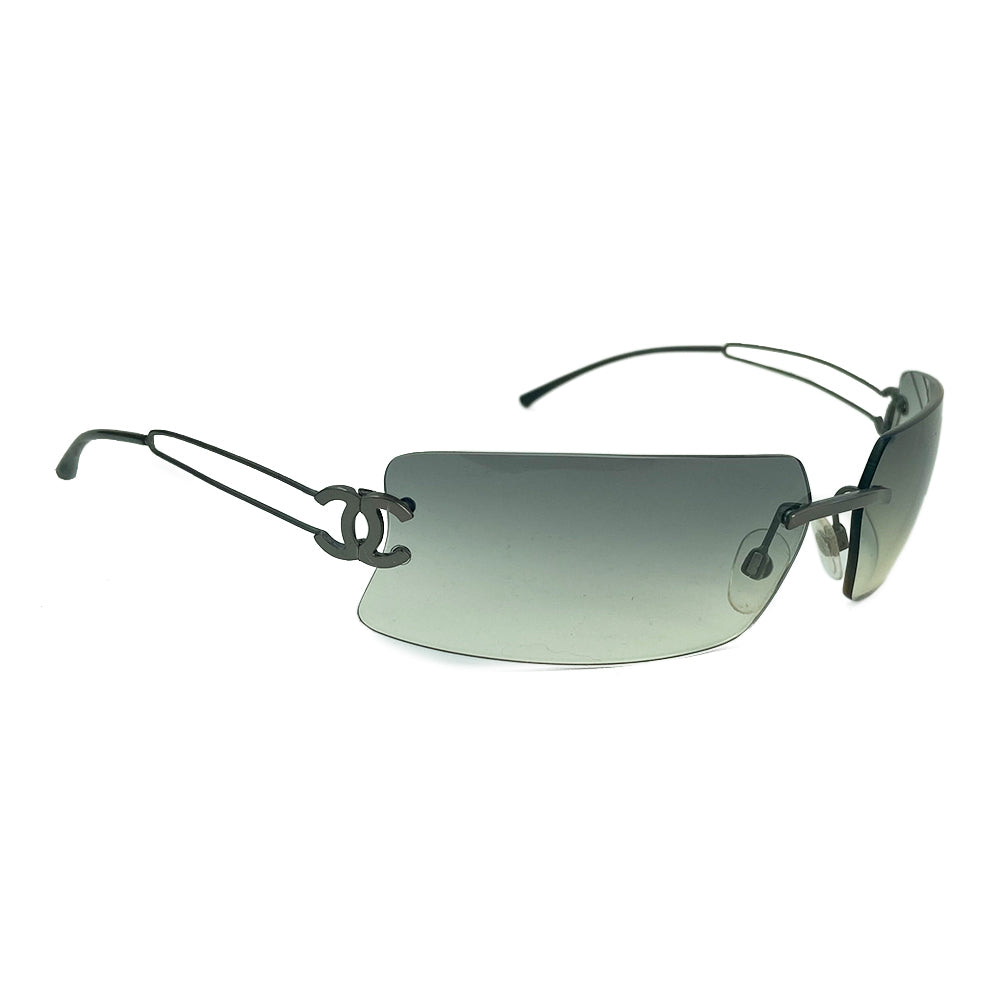 Chanel rectangular rimless sunglasses with gray gradient lenses, double wire side arms and CC metal logo at sides. Red cleaning cloth and white hard case included