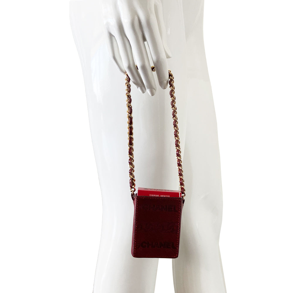Chanel burgundy pony & lamb leather cigarette case by Karl Lagerfeld for Chanel, circa 2000-2002. Open top mini pouch with CHANEL and interlocking chain design engraved into the pony hair panel on one side, red contrast stitching. Intertwined leather with gold-tone chain. Chanel logo interior stamp. Made in Italy