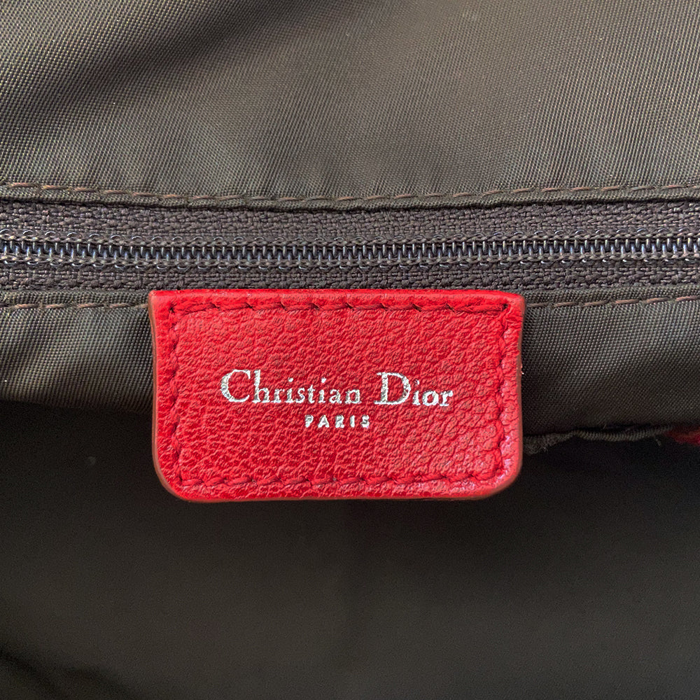 Christian Dior ad campaign Rasta Boston Bag by John Gallian for Dior. Beige and light brown Diorissimo canvas with silver-tone hardware, domed feet, 2 red leather rolled top handles, zipper pulls and end tab and red, yellow and green leather piping and tri-color leather front stripe. Made in Italy