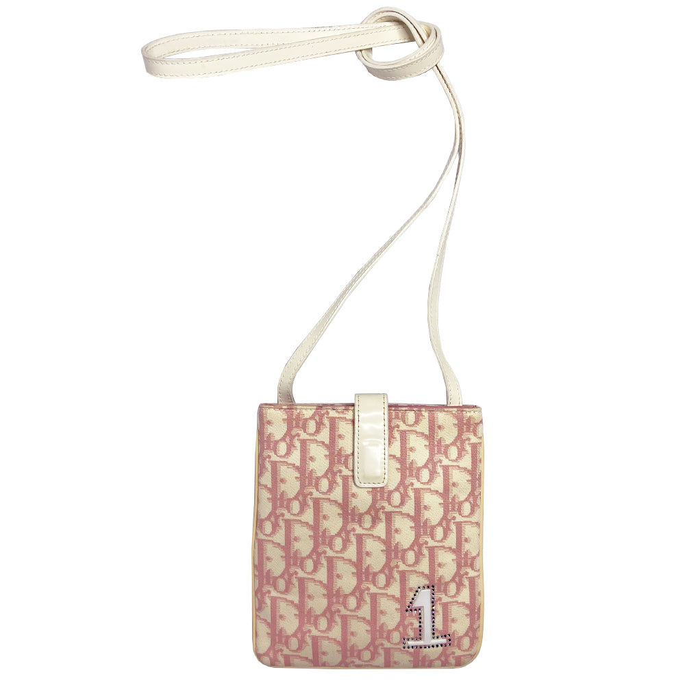 Christian Dior Girly pink monogram cross body reporter bag by John Galliano for Dior 2004 with pearl center white flowers, white piping, Swarovski crystal No 1 & Dior logo. Pink satin webbing adjustable shoulder strap with silver-tone Dior engraved sliders. Pink textile interior, one inner pocket. Made in Italy