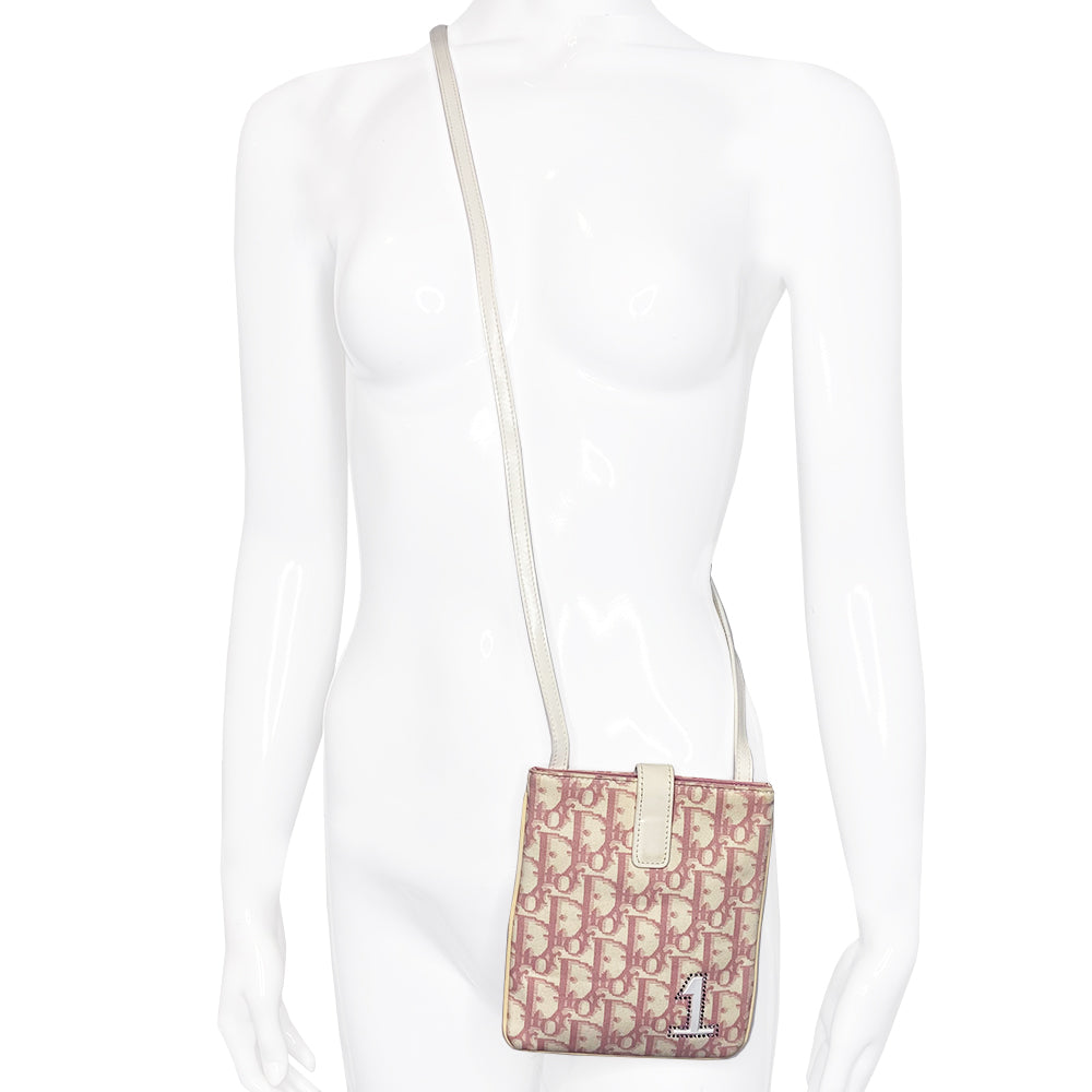 Christian Dior Girly pink monogram cross body reporter bag by John Galliano for Dior 2004 with pearl center white flowers, white piping, Swarovski crystal No 1 & Dior logo. Pink satin webbing adjustable shoulder strap with silver-tone Dior engraved sliders. Pink textile interior, one inner pocket. Made in Italy