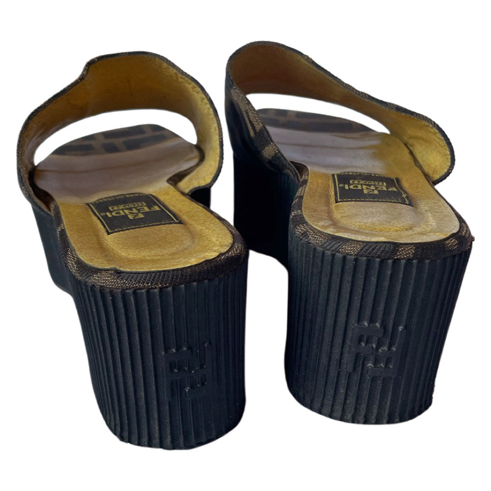 Fendi brown Zucca print fabric upper slip-on open toe slides with 2.5” black ribbed edge platform with small heel. Leather insoles with zucca fabric at inner sole toe, Fendi logo on inner sole, FF logos imprinted at outer platform. Made in Italy.