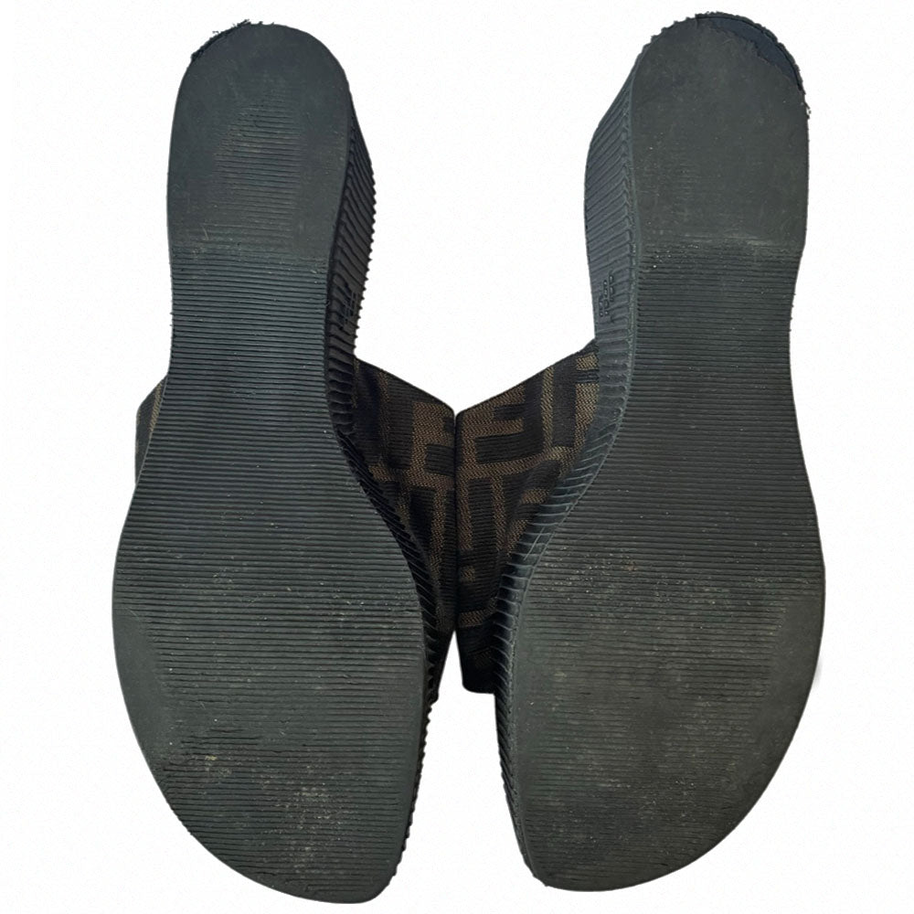 Fendi brown Zucca print fabric upper slip-on open toe slides with 2.5” black ribbed edge platform with small heel. Leather insoles with zucca fabric at inner sole toe, Fendi logo on inner sole, FF logos imprinted at outer platform. Made in Italy.