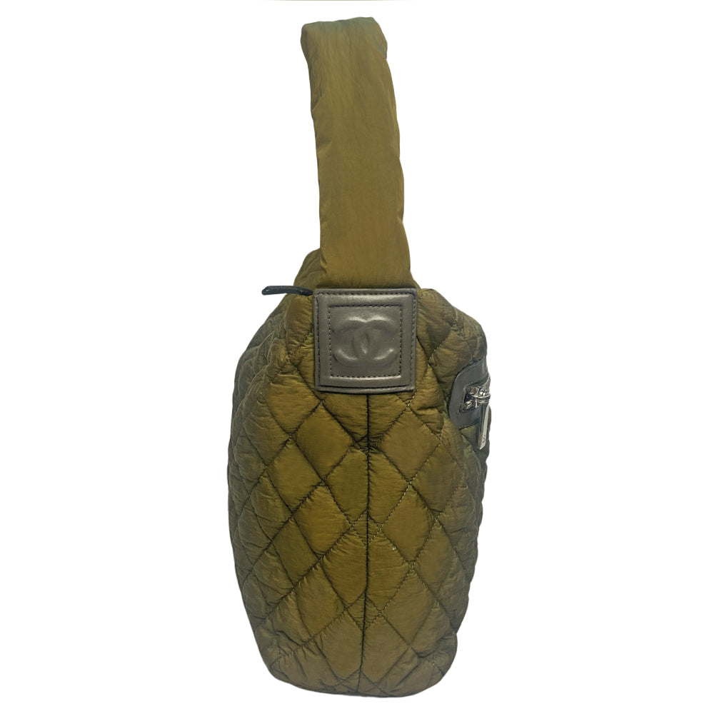 Chanel lightweight quilted green nylon shoulder bag by Karl Lagerfeld for Chanel, 2009/2010 with brown CC embossed brown leather accents at strap ends & around exterior silver-tone logo engraved outer pocket zipper. Interlocking CC stitched bottom logo. Zip top closure with red nylon interior, one zip pocket. Made in Italy