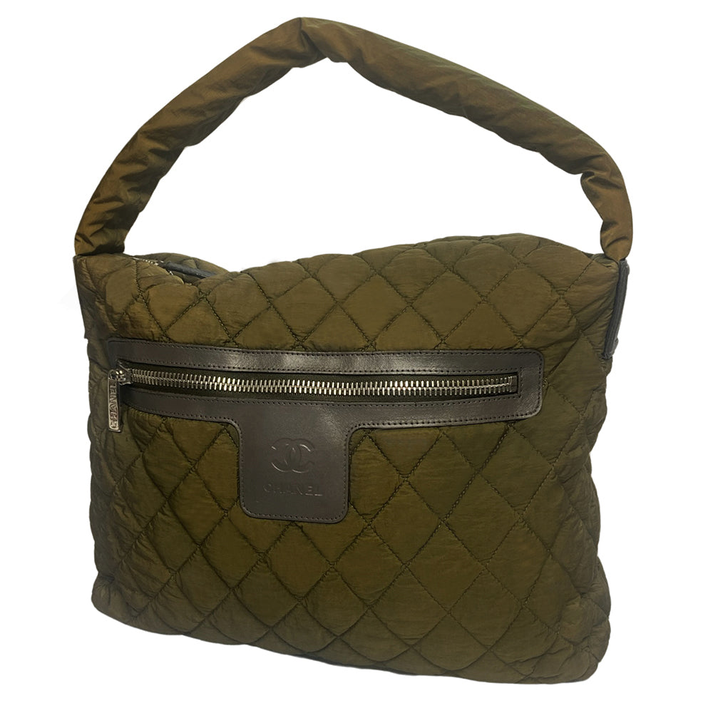 Chanel lightweight quilted green nylon shoulder bag by Karl Lagerfeld for Chanel, 2009/2010 with brown CC embossed brown leather accents at strap ends & around exterior silver-tone logo engraved outer pocket zipper. Interlocking CC stitched bottom logo. Zip top closure with red nylon interior, one zip pocket. Made in Italy