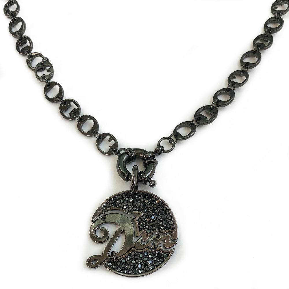 Christian Dior graphite-tone charm necklace. 9.25” chain links spell DIOR. Graphite tone crystals surround Dior signature pendant with front toggle clasp.
