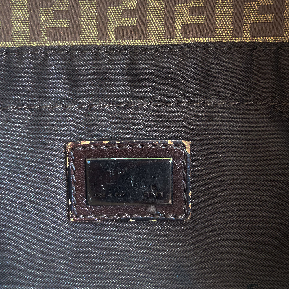 Fendi FF Zucca tan and brown canvas fabric baguette with adjustable chocolate color leather strap and accent, silver-tone Fendi engraved metal hardware and front logo. Front flap with single magnetic closure, canvas interior with Fendi engraved metal plate attached to single slip pocket. Made in Italy