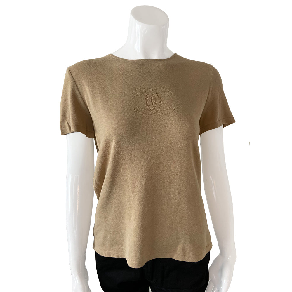 Chanel Tan color Short Sleeved Knit Top Interlocking with CC logo woven into fabric in front. Small repair to right shoulder, visually minimal while wearing. Short sleeves with round neck in fine rib knit of 100% cotton. Color: Tan Size: FR 44 Made in France