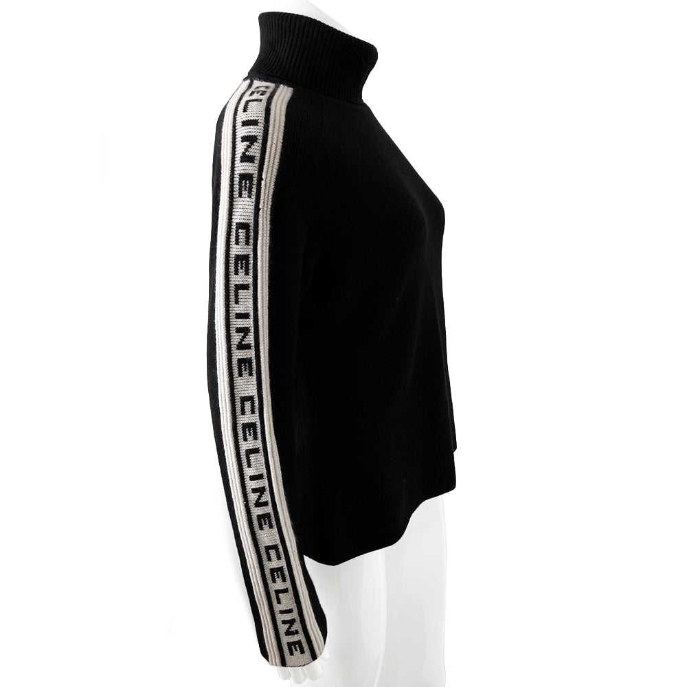 Celine cashmere logo sleeve turtleneck sweater from F/W 1999. Black ribbed high neck with long narrow sleeves and CELINE logo stripe in white and black running from cuff to neck on each arm. Fabric: 100% Cashmere. Size: L Made in Italy.