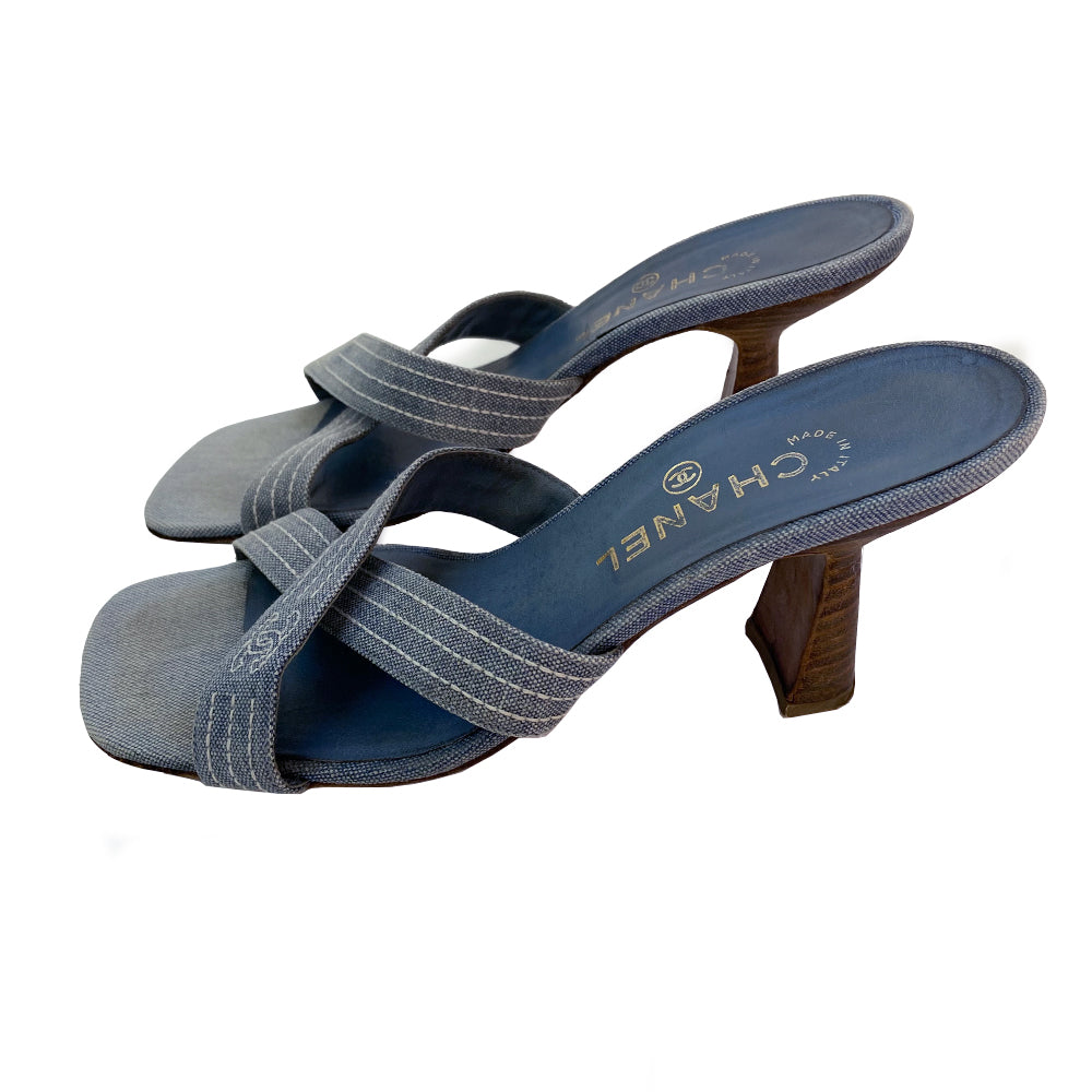 Chanel Blue Denim Criss Cross Slide Heels slip on style with criss cross denim and open toe with white accent stitching and CC logo, tan leather soles and wood heels Very good condition overall. Material: Denim upper, leather inner sole, leather bottom sole Color: light blue Size: 39 Made in Italy