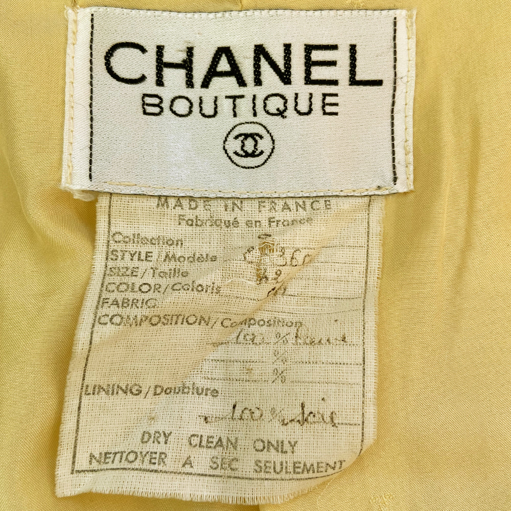 Chanel Boucle Jacket and Skirt Suit circa 1980’s in very good condition Jacket: Long sleeved with 4 pockets in front embellished with gold Chanel Rue Cambon logo buttons, 3 buttons at sleeves Skirt: Back invisible zipper with hook at waistband Size - Tag is hand written, seems to be FR: 42, fits like a medium Fabric: Main: 100%, Lining: 100% Silk Color: pale yellow Made in France
