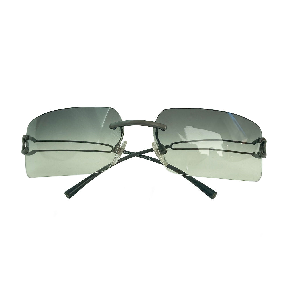 Chanel rectangular rimless sunglasses with gray gradient lenses, double wire side arms and CC metal logo at sides. Red cleaning cloth and white hard case included