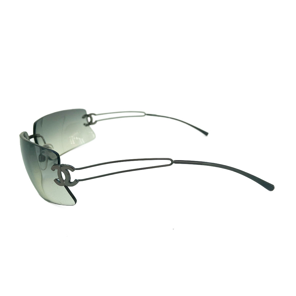 Chanel rectangular rimless sunglasses with gray gradient lenses, double wire side arms and CC metal logo at sides. Red cleaning cloth and white hard case included