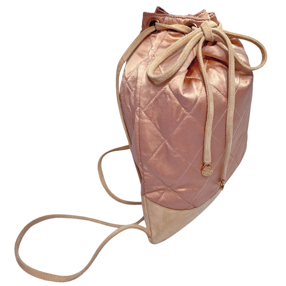 Chanel pink quilted satin and tan suede soft backpack by Karl Lagerfeld for Chanel 2001 with suede drawstring closure, silver-tone Chanel stamped tips and suede straps. Embedded faux pearls spell-out CHANEL embellishment on exterior suede satin interior with single slip pocket. Folds down flat. Made in France