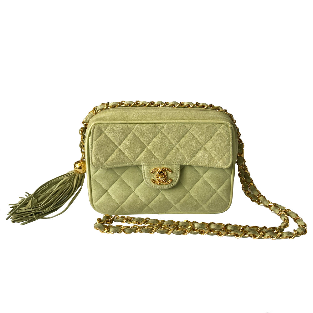 Chanel suede camera bag by Karl Lagerfeld for Chanel, 1991-94. Pistachio color quilted suede, top zipper, etched gold ball and tassels zipper pull, suede and gold chain shoulder strap. Outer flap pocket with engraved gold CC turn-lock, tonal leather lining, patch slip and zippered pocket with gold zipper pull. Made in France
