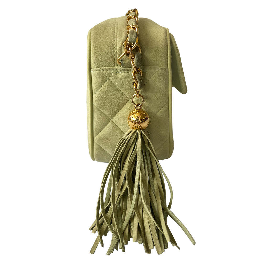 Chanel suede camera bag by Karl Lagerfeld for Chanel, 1991-94. Pistachio color quilted suede, top zipper, etched gold ball and tassels zipper pull, suede and gold chain shoulder strap. Outer flap pocket with engraved gold CC turn-lock, tonal leather lining, patch slip and zippered pocket with gold zipper pull. Made in France