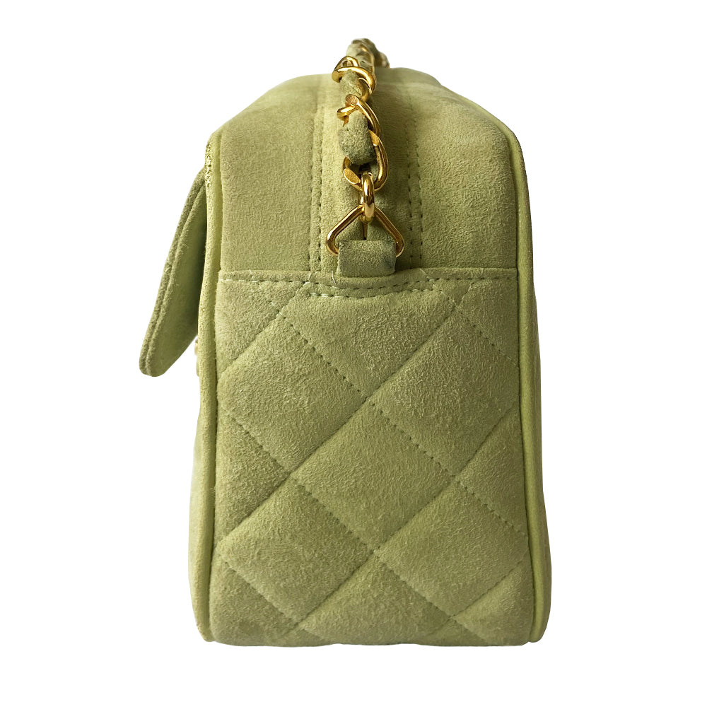 Chanel suede camera bag by Karl Lagerfeld for Chanel, 1991-94. Pistachio color quilted suede, top zipper, etched gold ball and tassels zipper pull, suede and gold chain shoulder strap. Outer flap pocket with engraved gold CC turn-lock, tonal leather lining, patch slip and zippered pocket with gold zipper pull. Made in France