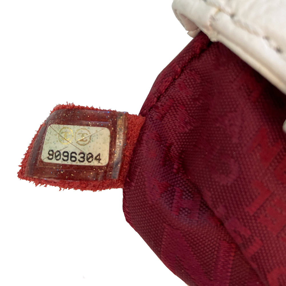 White Chanel Button Chain Quilted Shoulder Bag with 2 Gunmetal front buttons and 2 gunmetal chain link and interwoven leather straps, exterior quilted front pocket. Magnetic snap button closure, burgundy textile jacquard Chanel lining. Chanel Paris engraved on inside clasp. Interior hologram date code tag attached.
