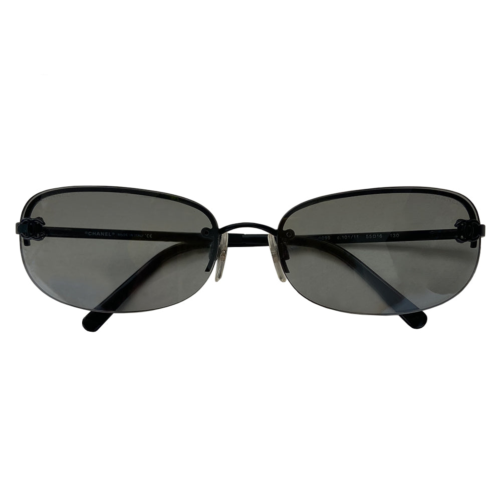 Chanel Black CC logo rectangle shape sunglasses with flat black metal frame along upper and frameless on the bottom with charcoal tinted lenses, black CC logo at each lens, Chanel engraved nose pad. Style: 4099 c.101/11 Made in Italy.