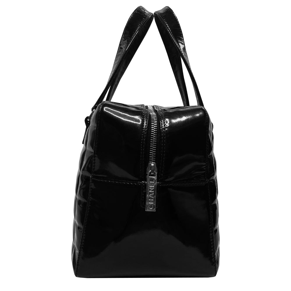 Chanel Chocolate Bar black patent leather quilted rectangular bowler tote by Karl Lagerfeld for Chanel 2003 with prominent interlocking CC front logo and 2 flat top handles, silver-tone hardware and feet. Dual Chanel engraved zipper closure with red microfiber lining and one zip pocket. Made in Italy