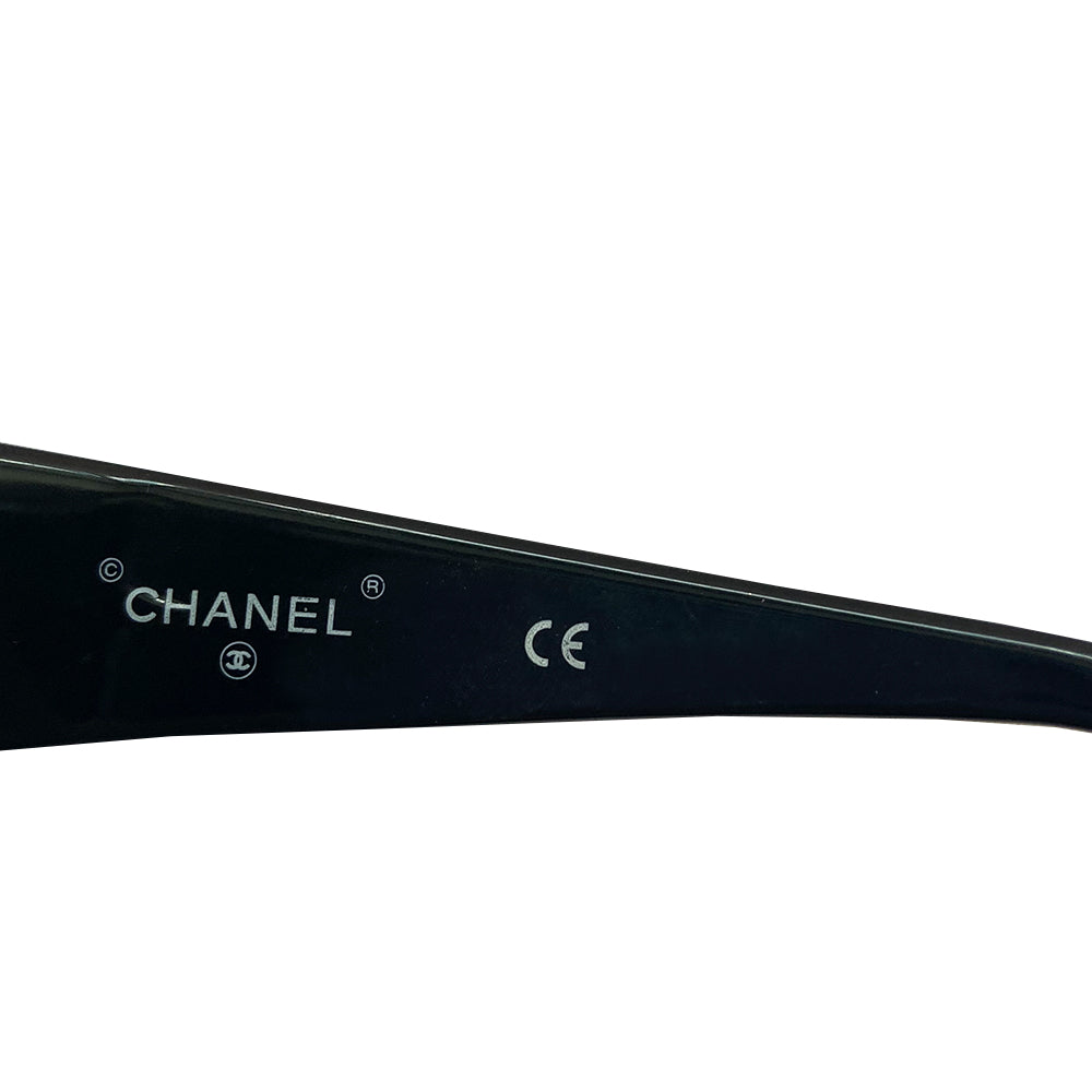 Chanel Paris CC logo black acetate frame sunglasses from the 1990’s by Karl Lagerfeld for Chanel embellished with gold-tone Chanel Paris engraved strip across the top from edge to edge and thick side arms and blue lenses. Style: 07798 94305. Made in Italy