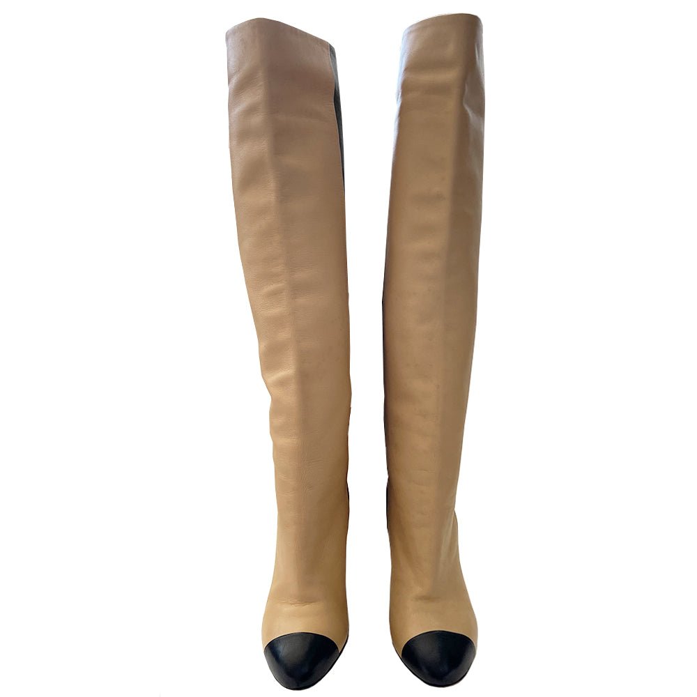 Chanel two-tone knee high lamb leather boots from Autumn 2008 by Karl Lagerfeld for Chanel. High heeled black/tan half and half slip-on to the knee heeled boots with black toe cap, gold-tone interlocking CC logo at back heels. Leather interior and soles. Size: IT 35 C. Made in Italy