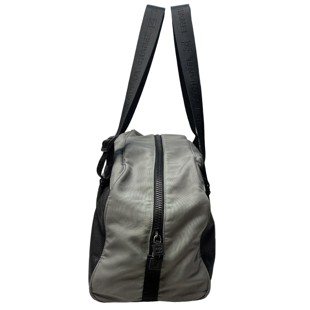 Chanel Sport bi-color grey canvas and black textured rubber canvas duffle/travel bag by Karl Lagerfeld for Chanel 2003/2004 with double zip closure, boxed rubber CC front logo. Double Chanel embossed adjustable satin webbing logo carry straps, logo padlock style black rubber zipper pulls, black nylon lining with single zip pocket. Made in Italy