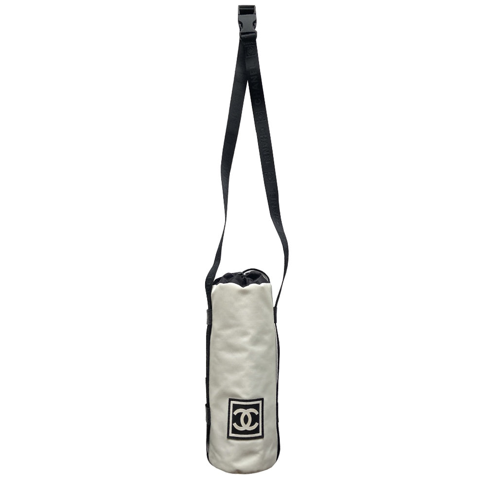 Chanel Sport canvas CC logo draw string water bottle holder by Karl Lagerfeld for Chanel, sport collection 2004. White and black nylon fabric with side zipper and CHANEL nylon webbing, adjustable long strap with sport clip closure. Box CC rubber front logo, black textile interior, date code tag attached. Made in Italy
