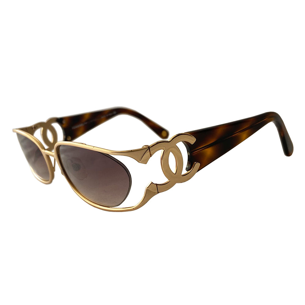 Chanel floating lens logo sunglasses by Karl Lagerfeld for Chanel with brushed gold-tone metal frame with cutout side CC logo at temples and floating brown tinted oval lenses, thick tortoise acetate arms. CHANEL printed on lens. Style: 4023 Made in Italy
