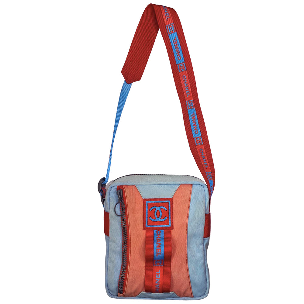 Chanel spring 2002 sport cross body canvas messenger bag by Karl Lagerfeld for Chanel with appliqué embroidered box CC front logo, outer zip pocket with ring zipper pull and long CHANEL CC logo satin webbing adjustable shoulder strap. Top zipper closure with blue vinyl interior, clear vinyl interior slip pocket. Made in Italy
