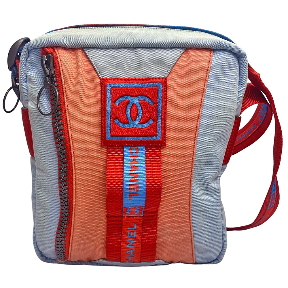 Chanel spring 2002 sport cross body canvas messenger bag by Karl Lagerfeld for Chanel with appliqué embroidered box CC front logo, outer zip pocket with ring zipper pull and long CHANEL CC logo satin webbing adjustable shoulder strap. Top zipper closure with blue vinyl interior, clear vinyl interior slip pocket. Made in Italy