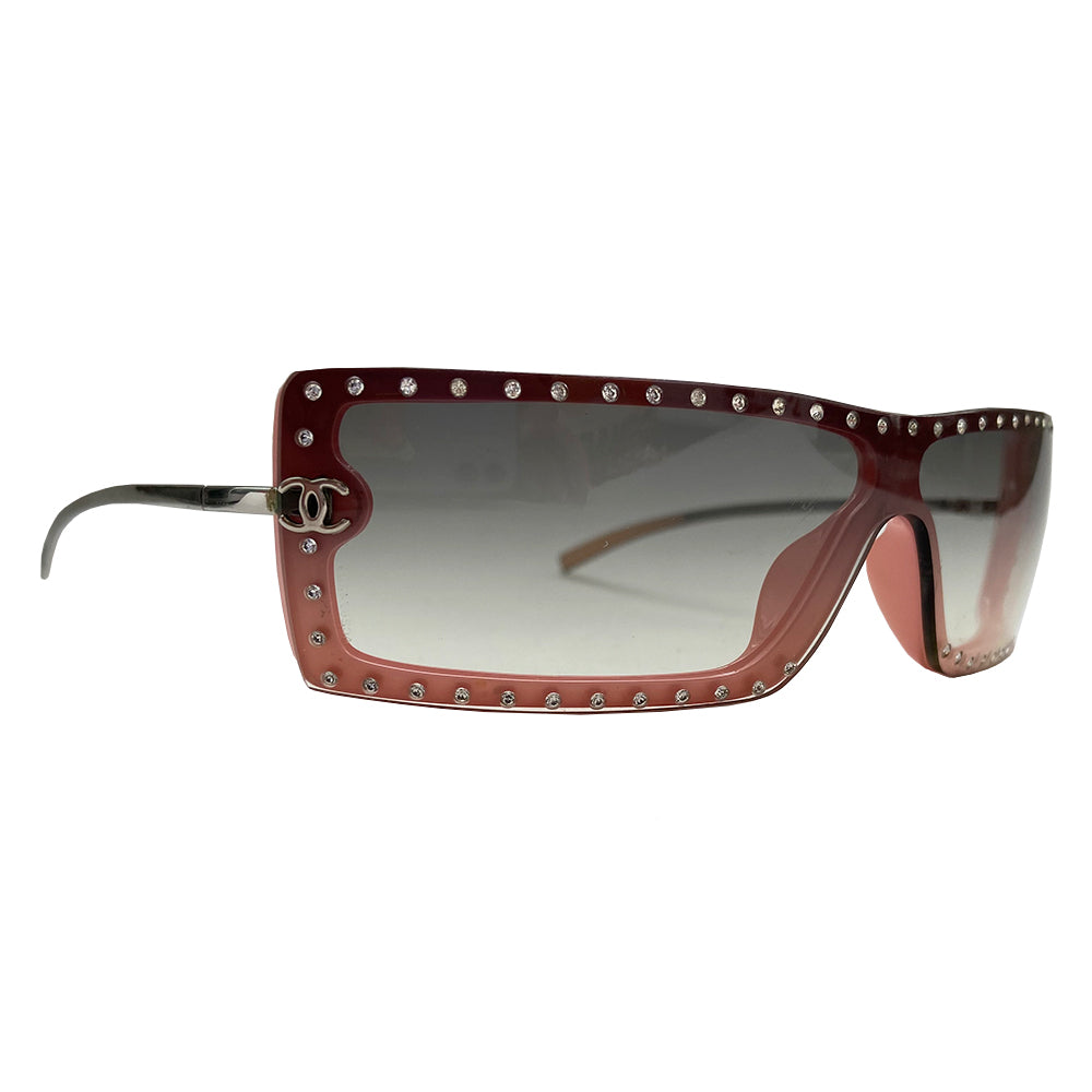 Chanel Pink Shield Frame with Crystal Sunglasses with curved rectangular shield frame and silver-tone metal arms. Swarovski crystals surround the lens with silver-tone interlocking CC logo on each side and CHANEL engraved arms. Color: Pink lens, Grey gradient lens. Made in Italy