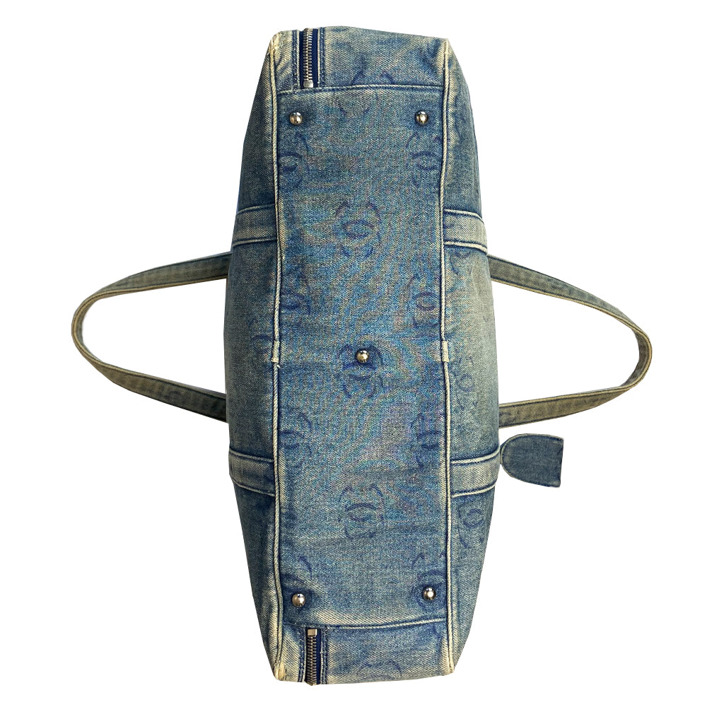 Chanel all over CC logo distressed denim overnight bag by Karl Lagerfeld for Chanel 2003 with detachable key pouch, outer slip pocket, dual zip closure, double carry handles. Jacquard textile CC logo print lining with zippered pocket, elastic compression straps to hold items in place. Serial number sticker attached.