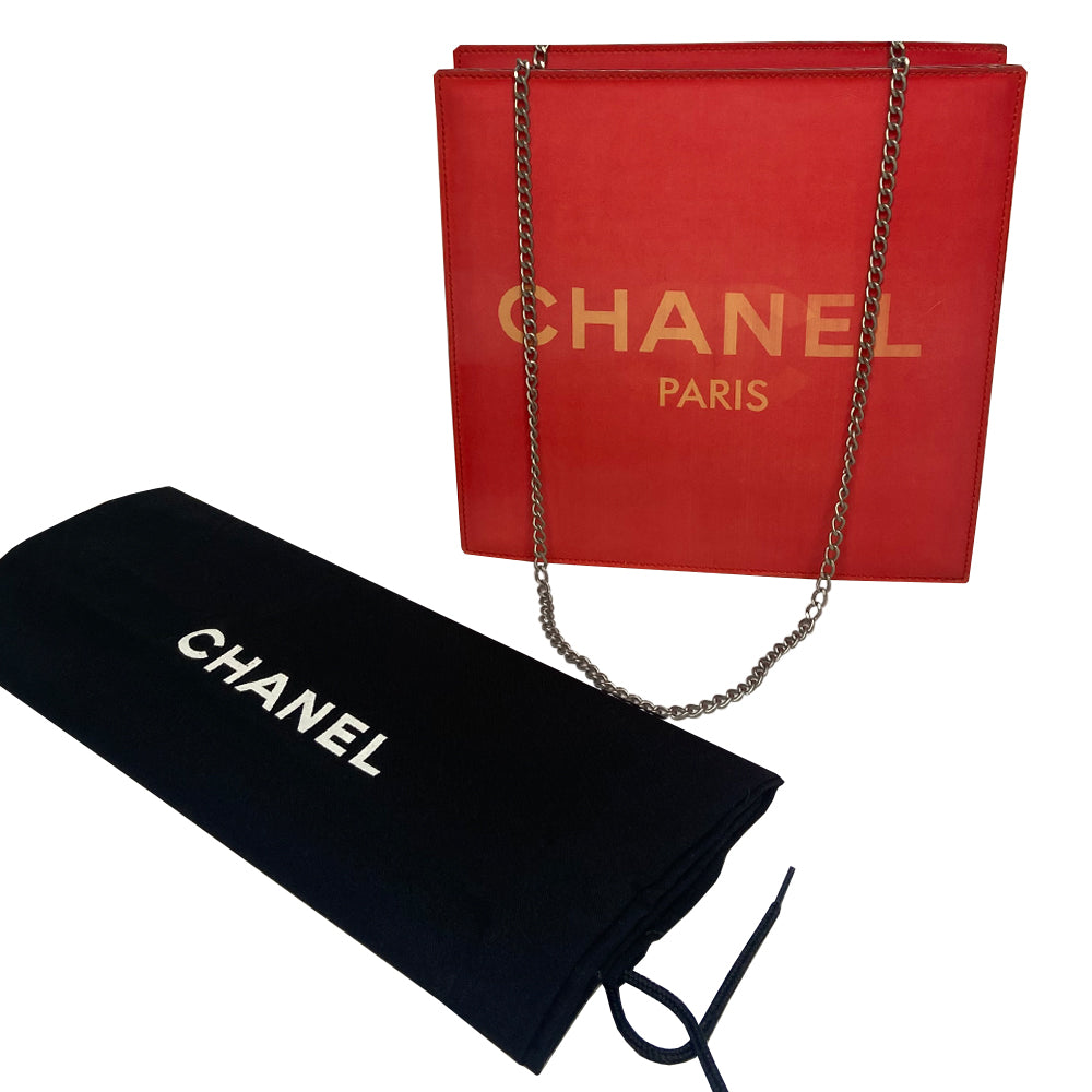 Chanel rectangular vinyl shoulder bag by Karl Lagerfeld for Chanel, 2000 with silver-tone double chain shoulder strap and lenticular/holograph design that flip flops between gold-tone interlocking CC logo and CHANEL Paris. Open top with vinyl interior and one zippered pocket. Made in France