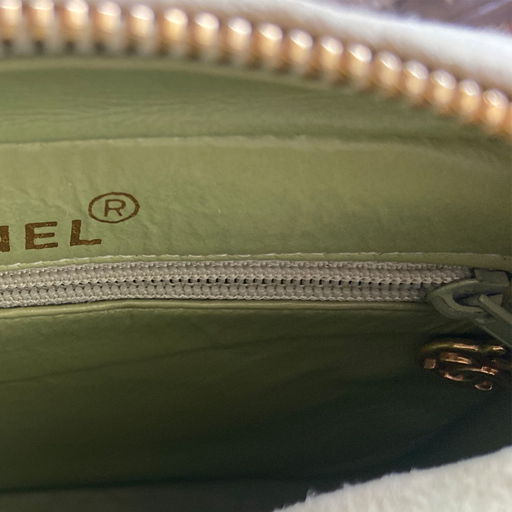 Chanel suede camera bag by Karl Lagerfeld for Chanel, 1991-94. Pistachio color quilted suede, top zipper, etched gold ball and tassels zipper pull, suede and gold chain shoulder strap. Outer flap pocket with engraved gold CC turn-lock, tonal leather lining, patch slip and zippered pocket with gold zipper pull. Made in France