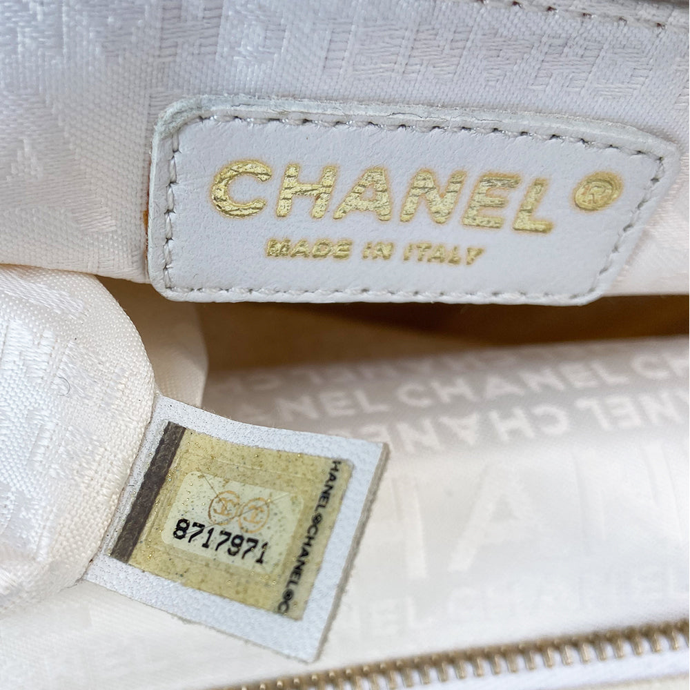 Chanel canvas Marshmallow Tote by Karl Lagerfeld for Chanel 2003-2004. White canvas tote with taupe handles and accent, stitched interlocking CC front logo, protective bottom feet. Gold-tone top zipper and hardware Chanel printed textile interior with one interior zip pocket. Made in Italy
