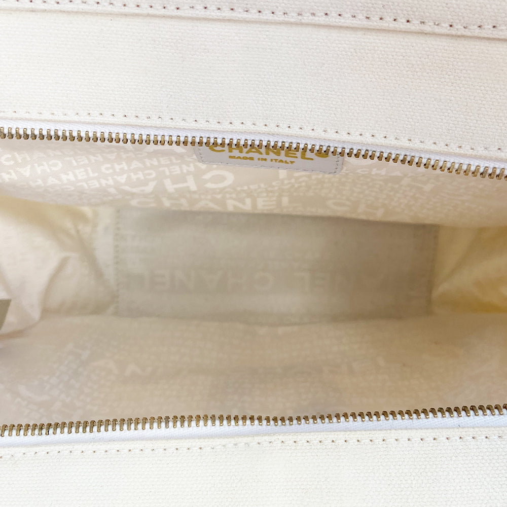 Chanel canvas Marshmallow Tote by Karl Lagerfeld for Chanel 2003-2004. White canvas tote with taupe handles and accent, stitched interlocking CC front logo, protective bottom feet. Gold-tone top zipper and hardware Chanel printed textile interior with one interior zip pocket. Made in Italy