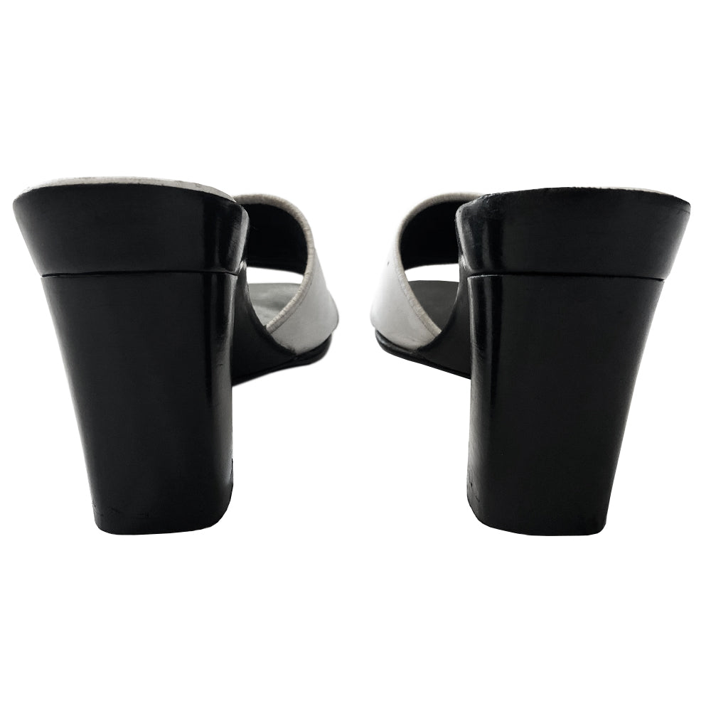 Chanel white square toe slip on mules with black leather covered block heels, leather upper with embroidered interlocking CC logo and edging. White and black leather insole with leather bottom sole. Made in Italy