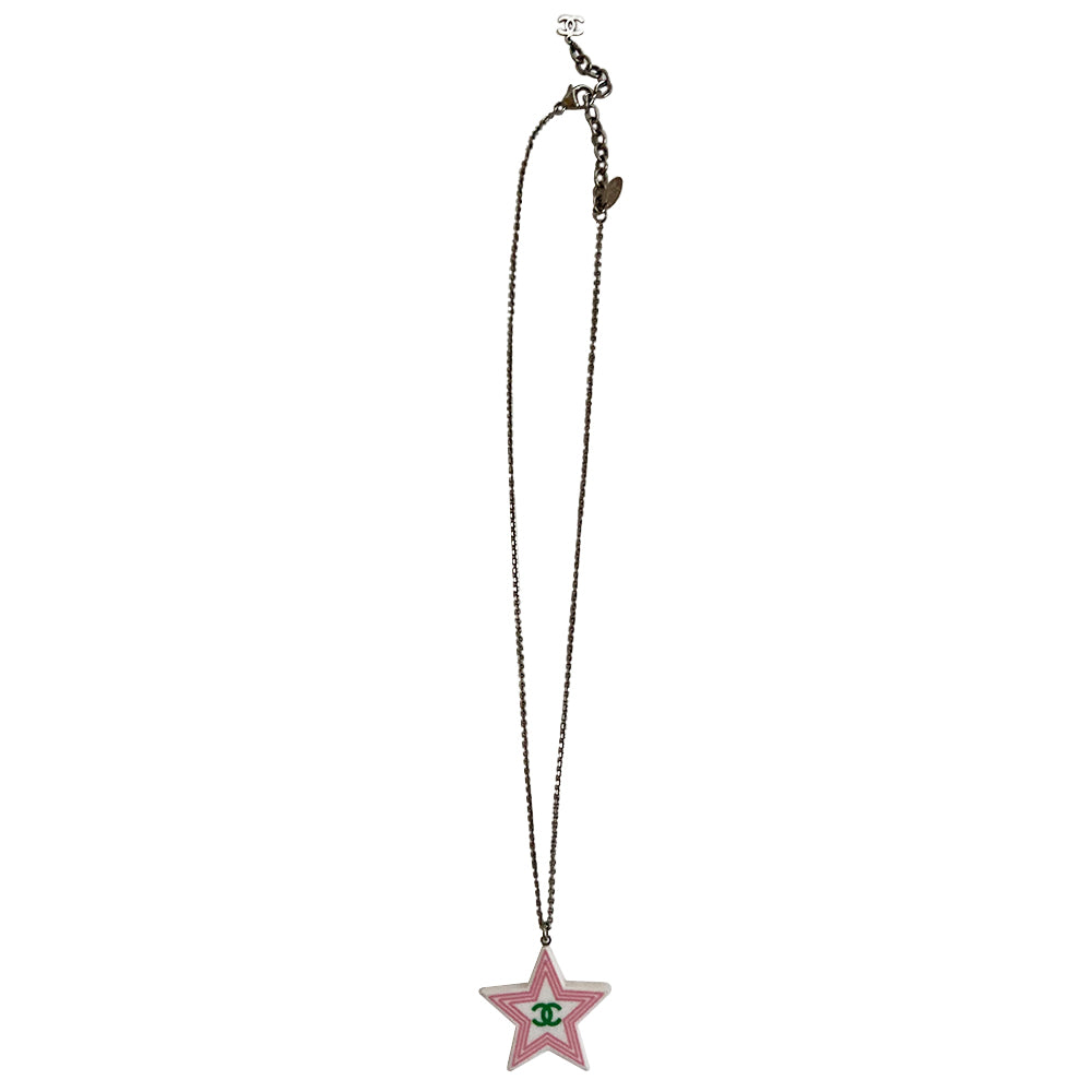 Chanel 2 sided white resin star pendant necklace by Karl Lagerfeld for Chanel Cruise collection, 2004 with pink border and yellow CC logo on one side, green logo on the other. Silver-tone long chain with lobster closure, interlocking metal CC logo charm at one end and metal stamped tag attached. Made in France.