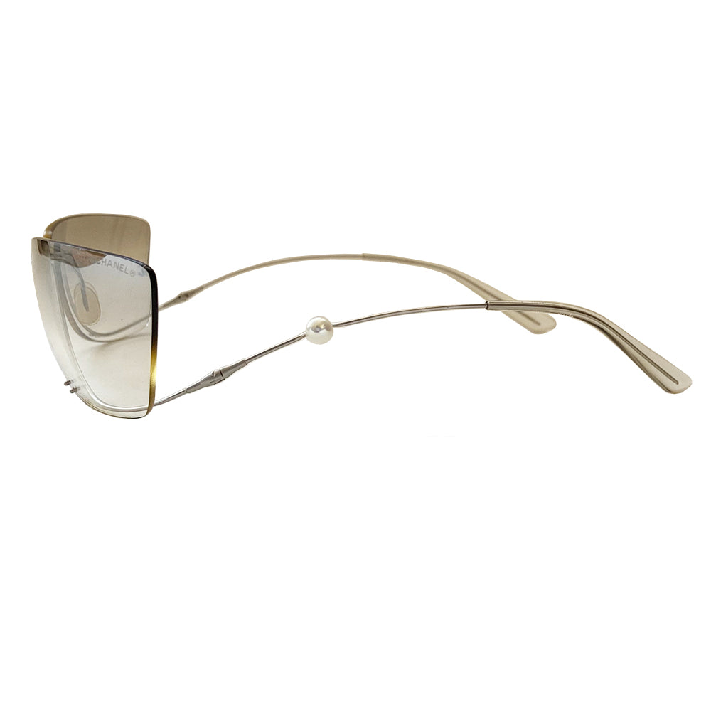 Chanel rimless fresh water pearl frameless sunglasses with light grey to clear gradient lenses and upside down flexible wire silver-tone frame. Silver-tone CC logo on right lens with a freshwater pearl embedded into the left arm. Case and cleaning cloth included. Style: 4053-H Made in Italy