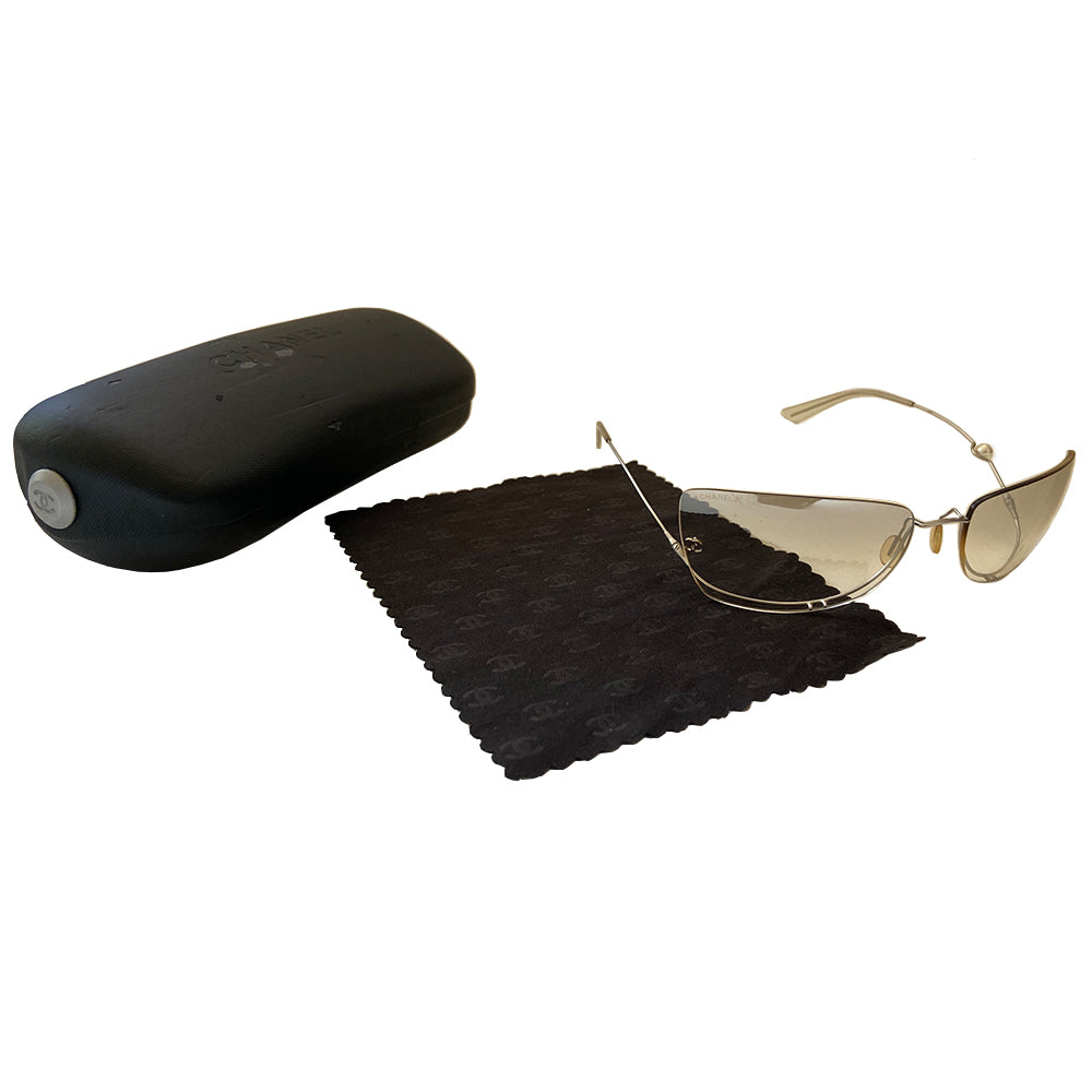 Chanel rimless fresh water pearl frameless sunglasses with light grey to clear gradient lenses and upside down flexible wire silver-tone frame. Silver-tone CC logo on right lens with a freshwater pearl embedded into the left arm. Case and cleaning cloth included. Style: 4053-H Made in Italy