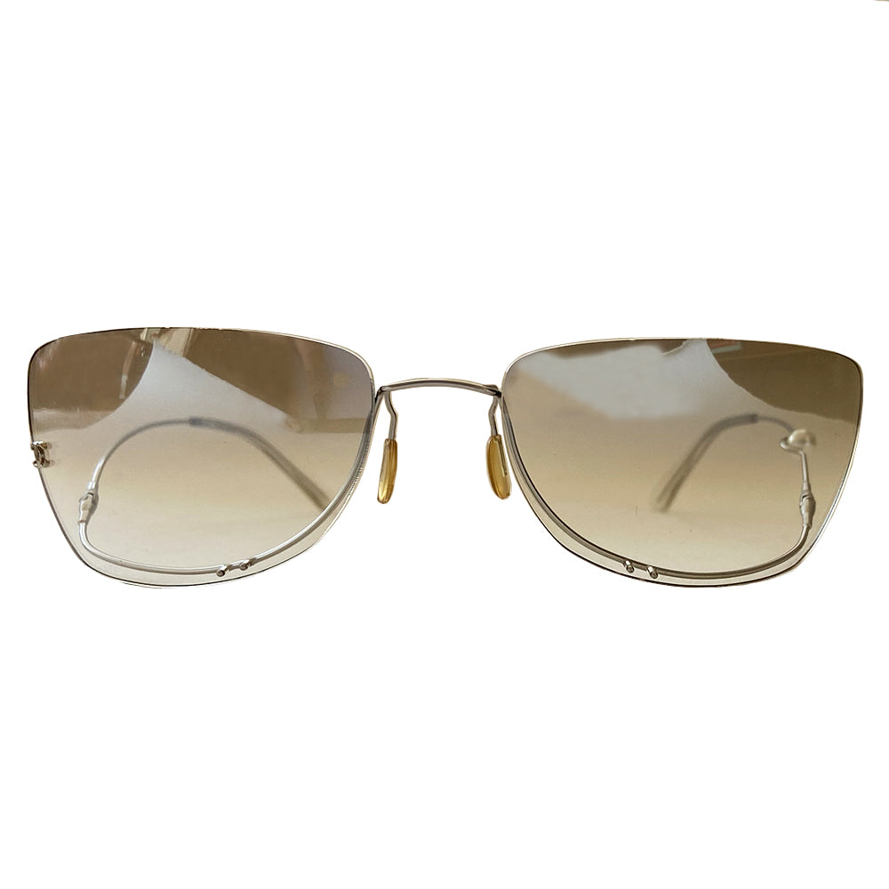 Chanel rimless fresh water pearl frameless sunglasses with light grey to clear gradient lenses and upside down flexible wire silver-tone frame. Silver-tone CC logo on right lens with a freshwater pearl embedded into the left arm. Case and cleaning cloth included. Style: 4053-H Made in Italy