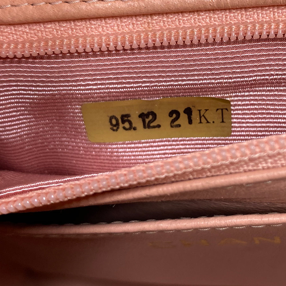 Chanel pink vertical quilt lamb leather bag by Karl Lagerfeld for Chanel, 1995 with envelope magnetic flap closure, interlocking CC raised leather front logo, rear outer slip pocket, long vertical quilted leather shoulder strap. Matching pink leather lining, slip pocket and grosgrain lined zippered pocket with gold medallion zipper pull. Made in France