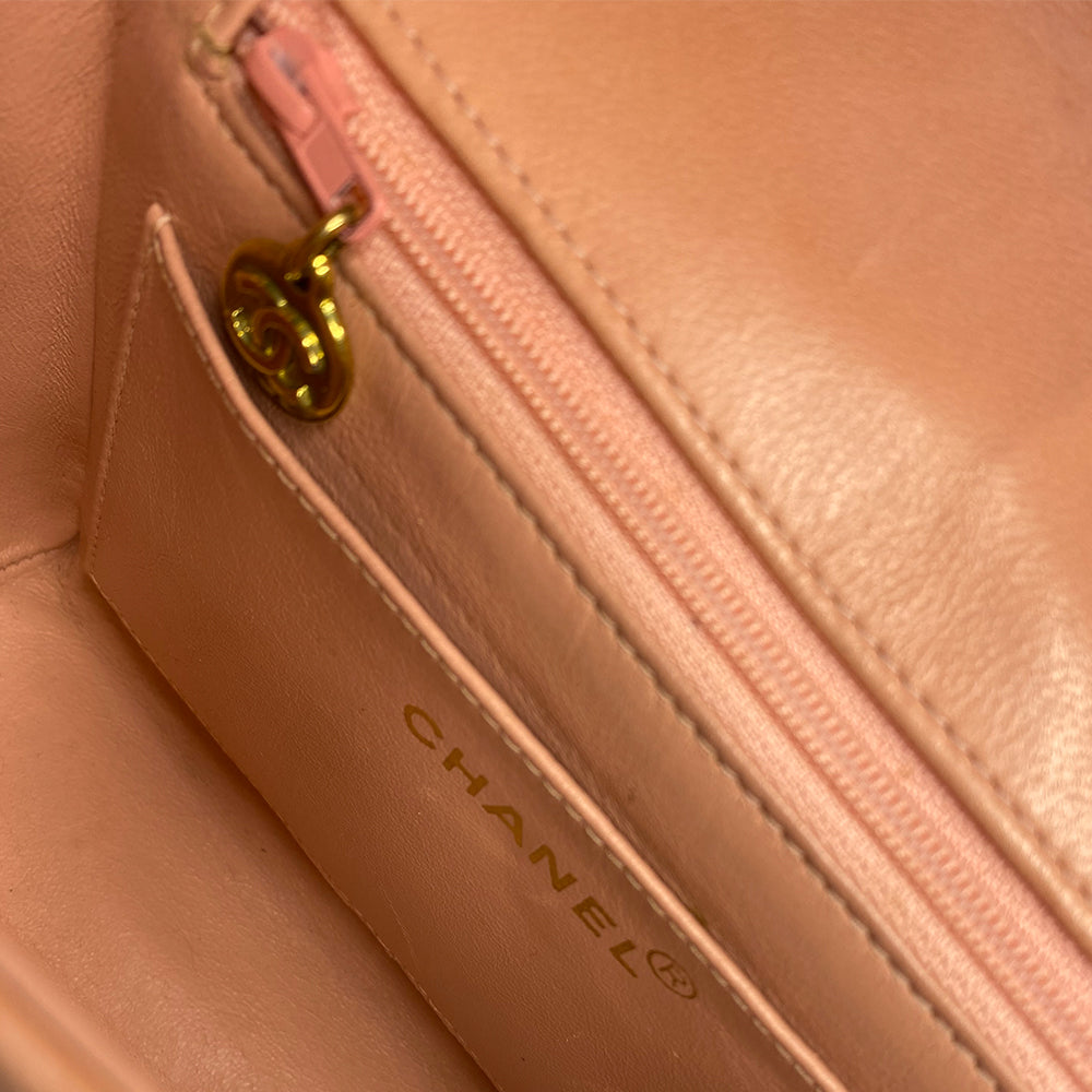 Chanel pink vertical quilt lamb leather bag by Karl Lagerfeld for Chanel, 1995 with envelope magnetic flap closure, interlocking CC raised leather front logo, rear outer slip pocket, long vertical quilted leather shoulder strap. Matching pink leather lining, slip pocket and grosgrain lined zippered pocket with gold medallion zipper pull. Made in France