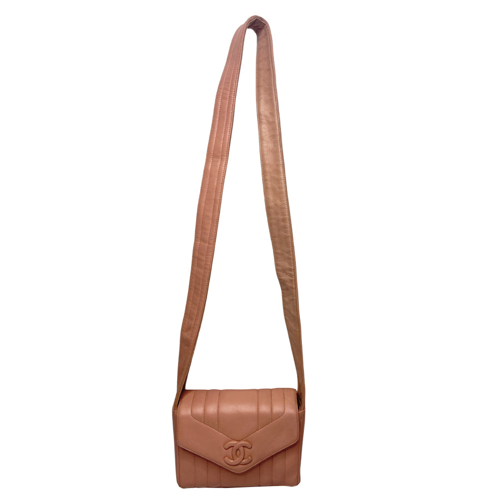 Chanel pink vertical quilt lamb leather bag by Karl Lagerfeld for Chanel, 1995 with envelope magnetic flap closure, interlocking CC raised leather front logo, rear outer slip pocket, long vertical quilted leather shoulder strap. Matching pink leather lining, slip pocket and grosgrain lined zippered pocket with gold medallion zipper pull. Made in France