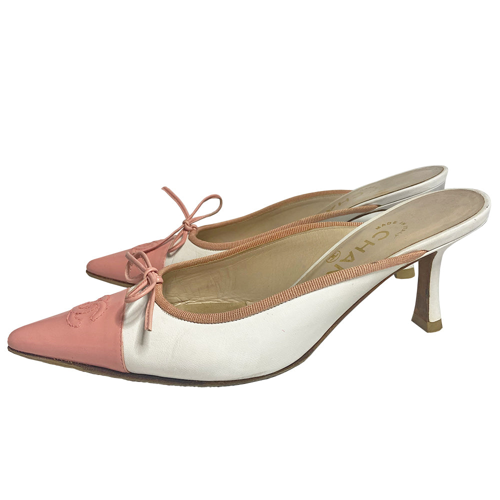 Chanel CC logo cap toe mules by Karl Lagerfeld for Chanel circa early 2000’s. White leather with pink pointed toe cap featuring tonal stitched interlocking CC logo with pink grosgrain edging and pink leather front bow. Leather upper, heels and sole. Made in Italy