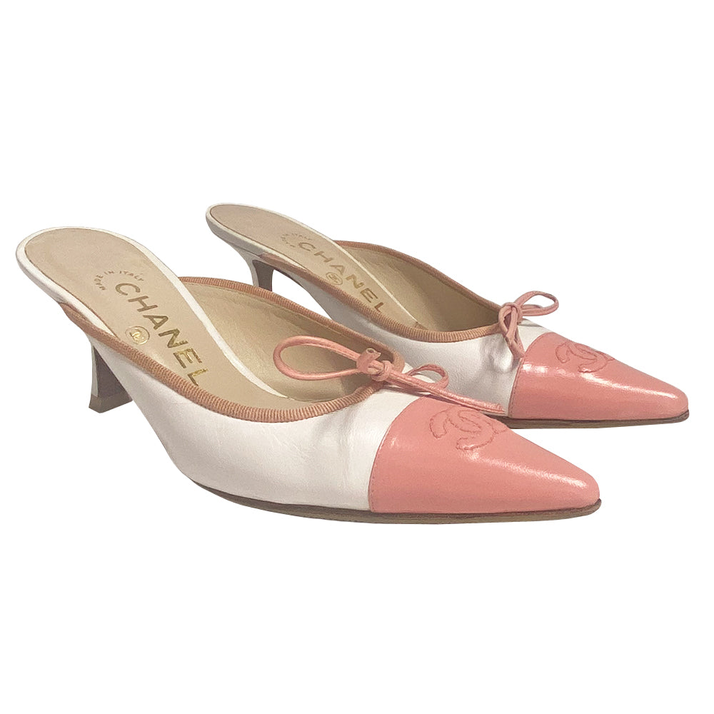 Chanel CC logo cap toe mules by Karl Lagerfeld for Chanel circa early 2000’s. White leather with pink pointed toe cap featuring tonal stitched interlocking CC logo with pink grosgrain edging and pink leather front bow. Leather upper, heels and sole. Made in Italy
